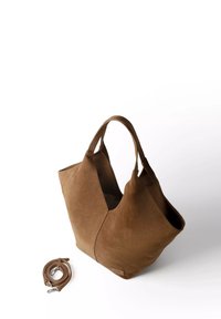 Sac fourre-tout en suède marron avec deux poignées et une bandoulière assortie amovible sur fond blanc.