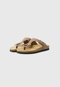 Sandales en cuir brun avec un semelle en liège, une tige en daim avec une accent de boucle, et une semelle noire texturée pour une meilleure adhérence.