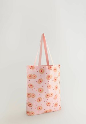 Rosa Tragetasche mit einem wiederholenden Muster aus herzförmigen Keksen und kleinen roten Herzen. Verfügt über zwei hellrosa Henkel und eine weiche Stofftextur.