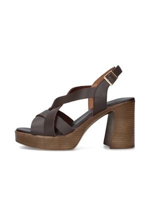 Sandalo in pelle marrone con tacco alto, cinturini incrociati, fibbia regolabile alla caviglia e tacco a blocco in legno con suola platform.
