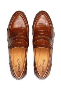 Mocassins en cuir brun avec une texture embossée crocodile, une finition lisse et des semelles intérieures de couleur brun clair contrastantes. Design à enfiler avec un matériel minimal.