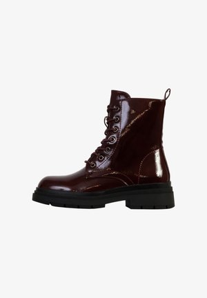 Bottine à lacets en vernis rouge foncé brillant avec une épaisse semelle noire et une languette au talon, vue de côté sur fond blanc.