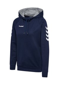 Granatowa bluza z kapturem z szarym wewnętrznym podszyciem kaptura, białe logo hummel na piersi i białe paski w kształcie szewronów na rękawach, kaptur ze sznurkiem.