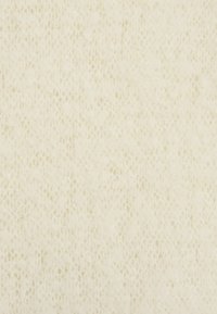 Detalle de una suave tela de punto de color crema con un sutil patrón de encaje y una textura ligeramente difusa.