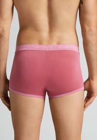 Burgundyröda boxer kalsonger med en mjuk, elastisk midja och kontrasterande rosa detaljer, som visar upp en sömlös, åtsittande design och mjuk textur.