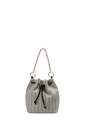 Pequeño bolso tipo cubo con patrón tejido en blanco y negro, cierre con cordón negro y asa de cadena dorada con anillas.