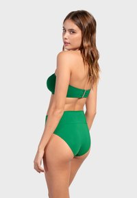 Grön tvådelad bikini med en strapless topp med spänne och högmidjade bottnar. Slät textur, enfärgad utan mönster.