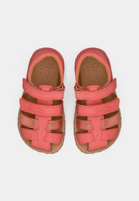 Σανδάλια σε κοραλλί χρώμα με πολλαπλούς ιμάντες, κατασκευασμένα από ευέλικτο υλικό. Διαθέτουν ταμπά πάτο με ανάγλυφο λογότυπο και εξωτερική σόλα από υφή λάστιχου.