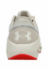 Laufschuh mit einem weichen grauen Obermaterial, das ein auffälliges weißes Logo an der Ferse und eine lebhafte rote Sohle für besseren Halt aufweist.