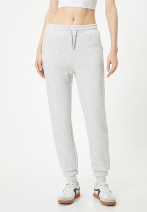 Lichte grijze sweatpants van zachte stof, met een elastische tailleband met trekkoord, zijzakken en boorden bij de enkels.