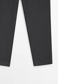 Pantalon gris foncé sur mesure, montré de la mi-cuisse à l'ourlet, avec un motif de tissu texturé subtil sur un fond blanc.