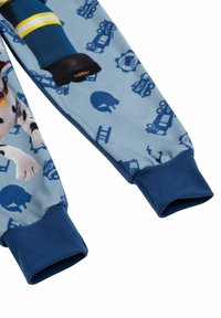 Set di pigiama per bambini realizzato in tessuto blu con motivi di veicoli e personaggi, polsini a coste blu navy e una texture morbida e liscia.