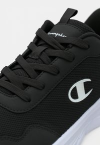 Μαύρο αθλητικό παπούτσι από διχτυωτό και συνθετικό υλικό με μαύρα κορδόνια, λευκό λογότυπο Champion στο πλάι και λευκή σόλα.