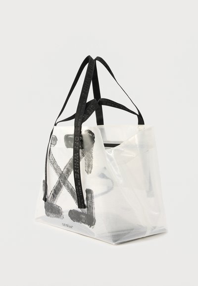 Διαυγής λευκή τσάντα tote με μαύρο αφηρημένο σχέδιο Χ και μαύρες λαβές με το λογότυπο Off-White, απεικονίζεται πάνω σε απλό φόντο.
