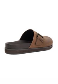 Brown leather slide sandals with a rounded toe, two metal buckles, and a textured dark sole. Smooth upper and cushioned footbed.