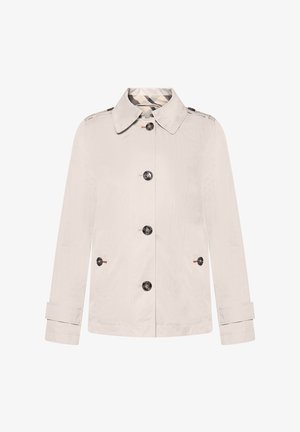 Lichtbeige jas van gestructureerde stof, met een knoopsluiting aan de voorkant, een puntige kraag en twee zijzakken met zwarte knopen.