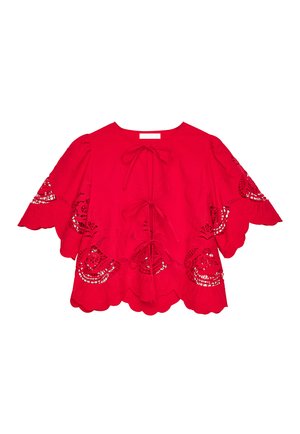 Red blouse featuring scalloped edges, short sleeves, and intricate cut-out designs. Finished with a front bow tie closure.