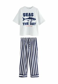 Witte katoenen T-shirt met marineblauwe grafische tekst "SEAS THE DAY" en vissenontwerp; gecombineerd met marineblauwe en witte gestreepte broek met elastische taille.