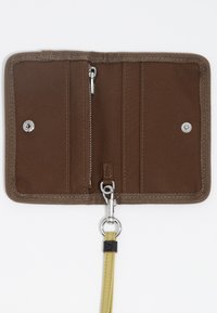 Cartera de tela marrón con un compartimento con cremallera, múltiples ranuras para tarjetas y una correa amarilla con un accesorio de metal plateado.