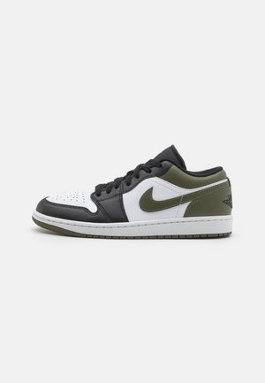 Laag uitgesneden sneaker met een bovenwerk van zwart, wit en olijfgroen leer, gestikte details en een textuur rubberen zool.