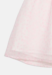 Ανοιχτό ροζ ύφασμα με μοτίβο μικρών, σκορπισμένων πιο σκούρων ροζ καρδιών και απαλώς κυρτή κάτω άκρη.