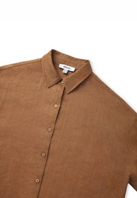Brown linen button-up shirt with a collar, featuring seven buttons down the front, a soft texture, and a relaxed fit design.
