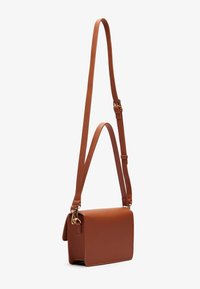 Brown leather crossbody bag with a rectangular shape, adjustable strap, gold hardware accents, and a smooth texture.