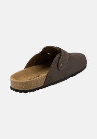 Sandale à glissière en cuir brun avec une semelle en liège, forme arrondie, sangle réglable avec fermeture à pression et détails de couture contrastants.