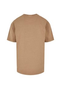 Kortærmet t-shirt med rund hals i lysebrunt stof, der har en glat tekstur og en lige skæring uden mønstre eller pynt.