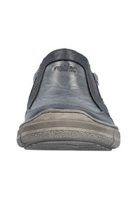 Szare skórzane buty wsuwane z teksturowaną gumową podeszwą, kontrastowym przeszyciem i logo z boku. Płaski fason z zaokrąglonym czubkiem.