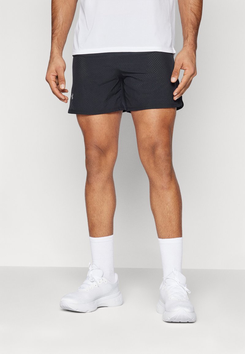 Schwarze Sportshorts mit Mesh-Textur, kombiniert mit weißen Socken und weißen Sneakers. Das Design zeichnet sich durch einen bequemen Schnitt und minimale Markenkennzeichnung aus.