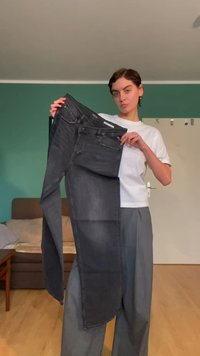 Svarte denimjeans holdt oppreist, med en klassisk fem-lommers design, lett falming og en smal passform. Materialet virker mykt med en jevn tekstur.