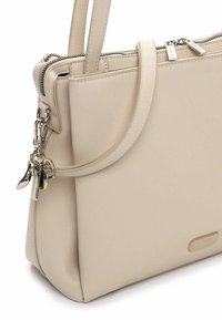 Beige håndtaske i syntetisk læder med en struktureret form, udstyret med to håndtag, en sølvfarvet lynlås og en lille logoplate foran.