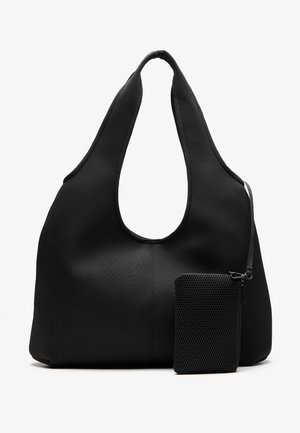 Grand sac fourre-tout en tissu noir doux avec de larges anses et une petite pochette zippée texturée attachée par une sangle sur fond blanc.