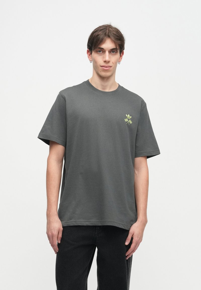 Grijze katoenen t-shirt met korte mouwen, voorzien van een klein groen logo op de linkerborst, ontworpen met een relaxte pasvorm en een gladde textuur.