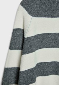 Maglione lavorato a maglia a strisce orizzontali grigie e bianche, con collo a costine e cucitura visibile sulla spalla.