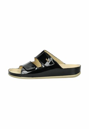 Sandales à glisser en cuir verni noir avec un bout ouvert, dotées de deux larges brides et d'une semelle beige. Texture lisse avec un léger éclat.