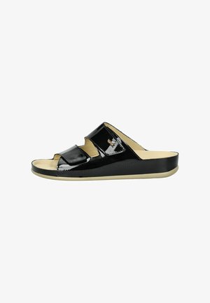 Sandali a scivolo neri in vernice con punta aperta, dotati di due ampi cinturini e una suola beige. Texture liscia con una leggera lucentezza.