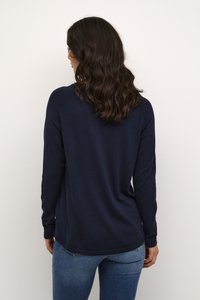 Tengerészkék, hosszú ujjú póló ívelt aljjal, puha textúrával és bordás mandzsettával. A hátoldalon laza szabás és diszkrét varrási részlet látható.