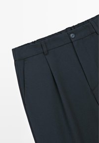 Tmavě námořnické kalhoty z texturované látky, s přímým střihem, předními záhyby a zapínáním na knoflík v pase.