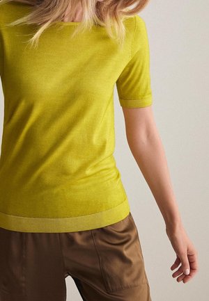 Top de manga corta en amarillo brillante, hecho de un material de punto suave. Presenta un cuello y dobladillo acanalados, con una silueta ajustada.