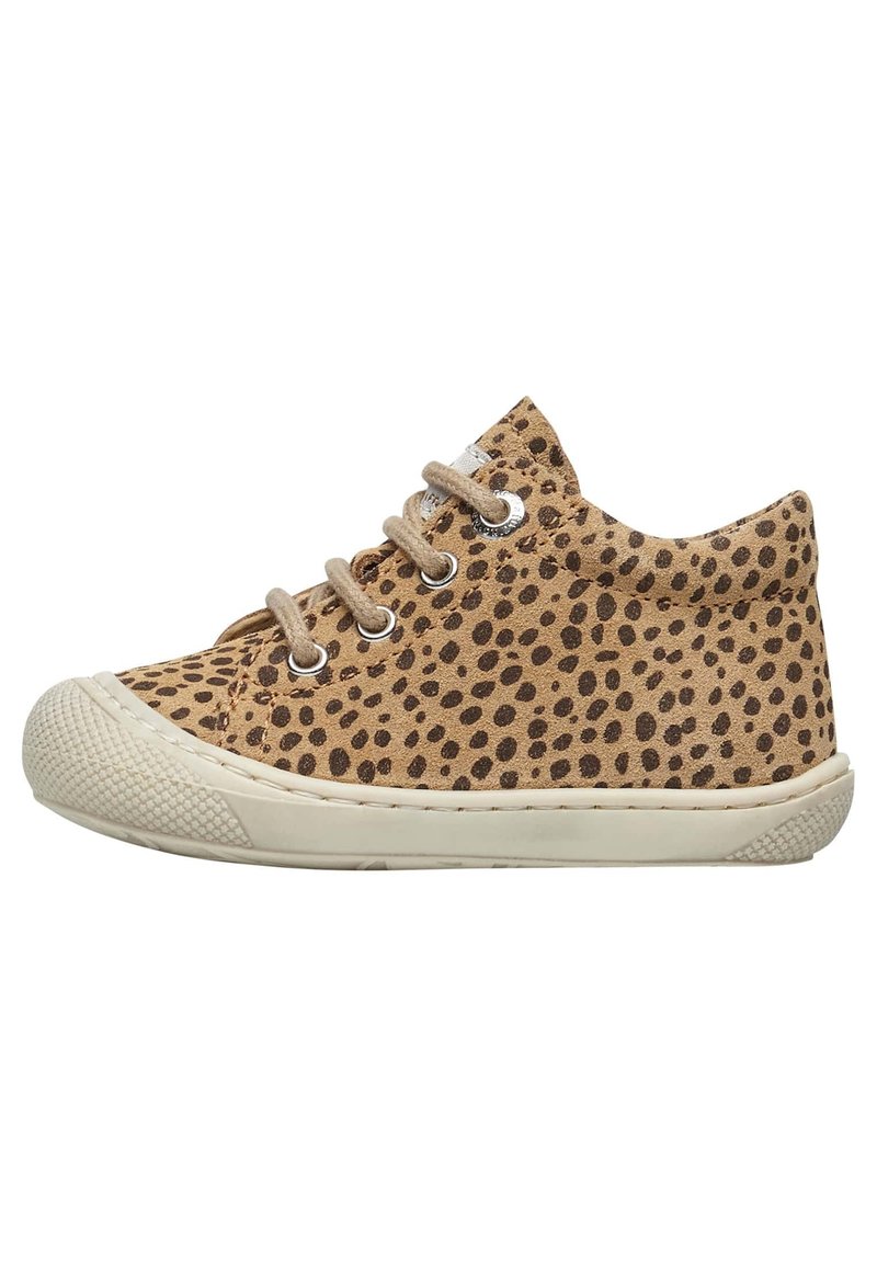 Sneaker in suede tan con pois neri, dotato di punta arrotondata, lacci e suola in gomma. Superficie texturizzata e dettagli minimal.