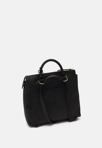 Schwarze Lederhandtasche mit zwei Griffen, abnehmbarem Schultergurt, goldenen Beschlägen und Reißverschlussverschluss an einem schlichten weißen Hintergrund.