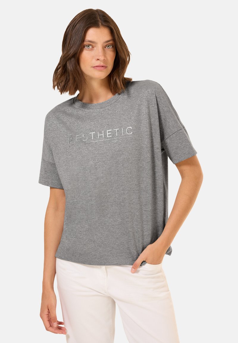 Grijze t-shirt met korte mouwen en "AESTHETIC" in zilveren letters op de borst gedrukt. Zachte textuur, ontspannen pasvorm, ronde halslijn.