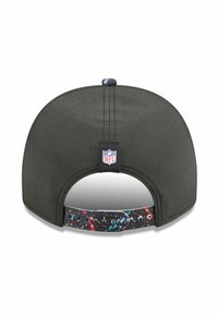 Casquette de baseball noire en tissu perforé, avec un design éclaboussé coloré sur la sangle ajustable et une étiquette logo NFL au dos.