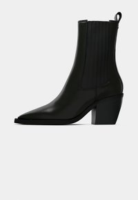 Must musta ankle saapad terava ninaga, elastsete külgpaneelidega ja tugeva kuusnurga kuuega. Sile tekstuur, minimalistlik disain.
