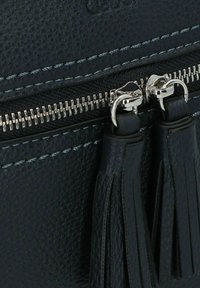 Borsa in pelle nera con superficie texturizzata, zip argentata e doppi dettagli a frangia. Presenta impunture blu a contrasto lungo i bordi.