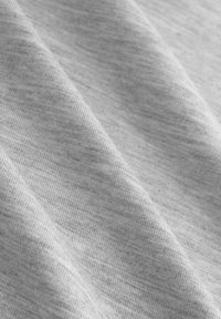 Tissu gris clair avec des plis doux et une texture fine côtelée créant de subtiles lignes diagonales sur la surface.