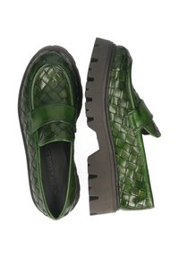 Zielone skórzane mokasyny wplecione w wzór, z grubą czarną masywną podeszwą, z paskiem na górze, pokazane z widoku z góry i z boku.