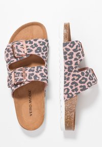 Różowe sandały w lamparcim wzorze mają podwójne regulowane paski, wyściółkę z amortyzacją oraz białą gumową podeszwę z teksturowaną krawędzią.